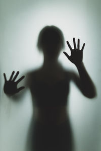 Shadow of person hand on glass