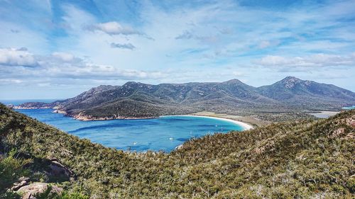 Scenic view of sea and mountains against sky