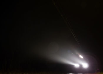 Close-up of illuminated lights against sky at night