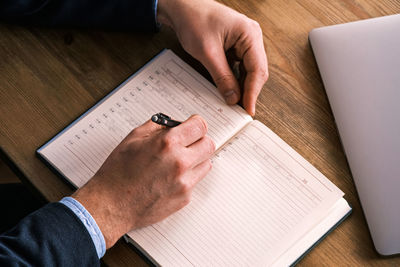 Cropped hands of businessman working on table