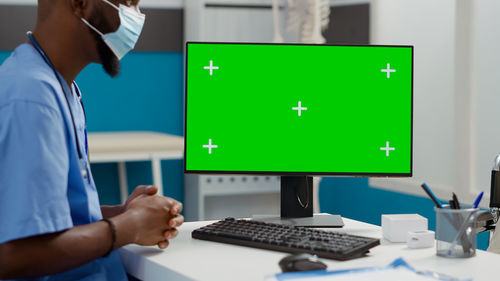 Midsection of man using laptop at office