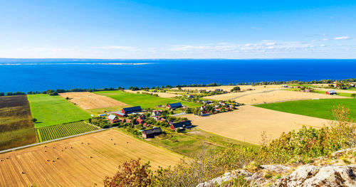 High angle view of agricultural field by sea against sky