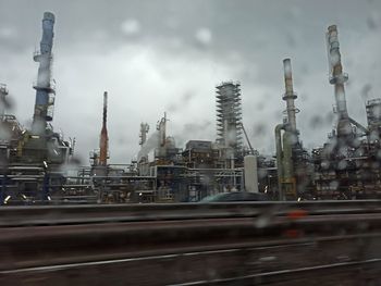 View of factory against cloudy sky