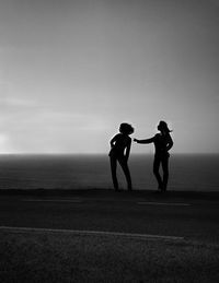 Women standing by sea against clear sky