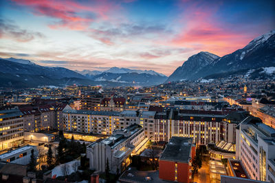 Aerial view of illuminated city against sky during dusk