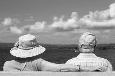 Elderly couple sitting on a bench by the lake. black and white photo.