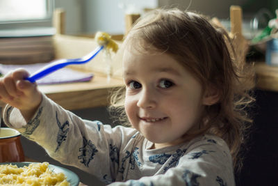 Portrait of girl eating food at home