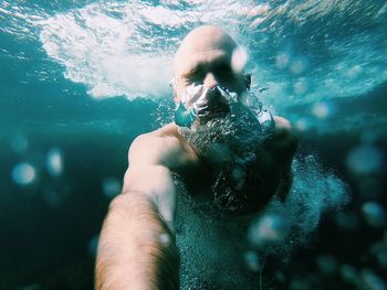 Portrait of young man swimming in sea