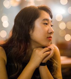 Young woman looking away in illuminated room