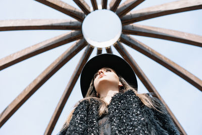 Low angle view of woman looking up under arch