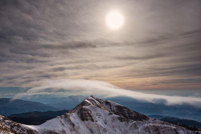 Scenic view of snowcapped mountains against sky during sunset