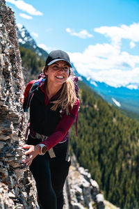 Hiker smiling on mountain ridge high above valley bellow