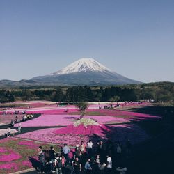People on landscape against clear blue sky