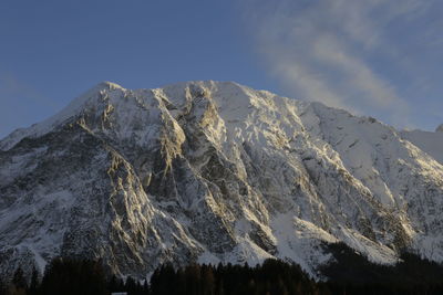 Low angle view of snowcapped mountains against sky