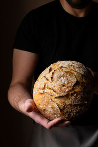 Midsection of man holding bread