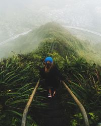 Rear view of woman walking on mountain against sky