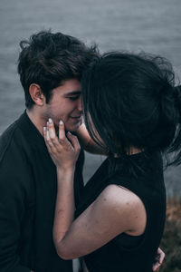 Close-up of couple standing face to face at beach