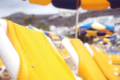 Close-up of yellow empty chairs at beach