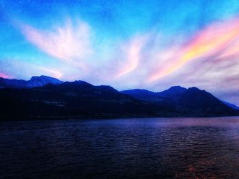 Scenic view of rainbow over lake against romantic sky