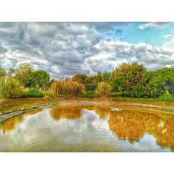 Scenic view of lake against cloudy sky