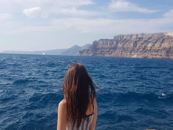 Rear view of woman looking at sea against sky