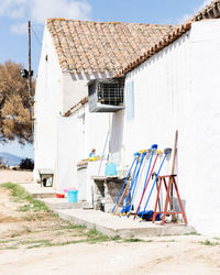 Lifeguard hut outside house on beach against sky