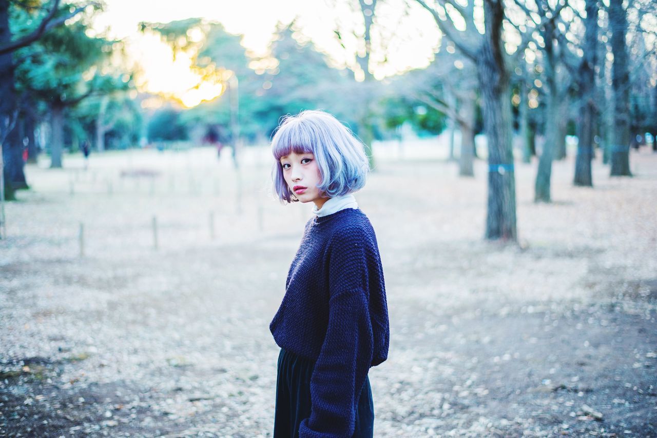 person, lifestyles, casual clothing, focus on foreground, looking at camera, front view, portrait, standing, leisure activity, young adult, smiling, three quarter length, waist up, warm clothing, happiness, tree, young women