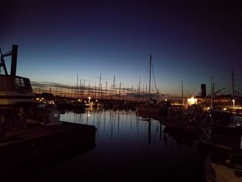 Sailboats moored at harbor against clear sky