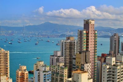 Boats in harbor with cityscape in background