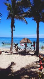 Palm trees on beach against sky