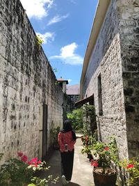 Rear view of people on wall by building