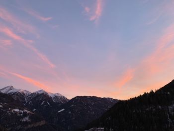 Scenic view of snowcapped mountains against sky at sunset