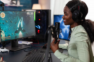 Side view of young woman using smart phone in recording studio