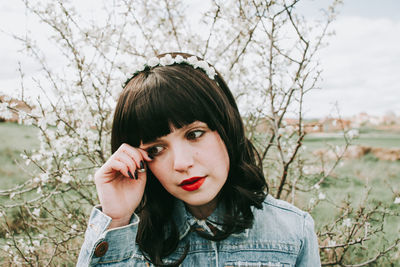 Portrait of young woman against plants