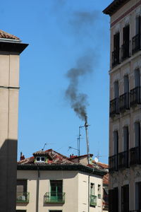 Buildings in city against blue sky