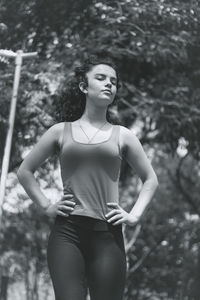 Teenage girl with hand on hip standing at park