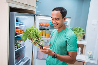 Man holding food while standing at home