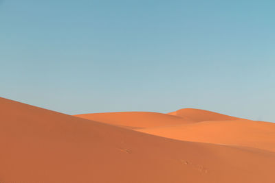 Scenic view of desert against clear blue sky