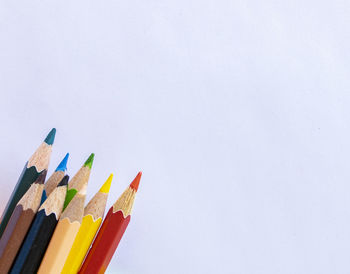 High angle view of colored pencils against white background