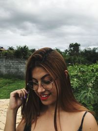 Smiling woman wearing eyeglasses against sky