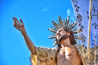 Low angle view of man against blue sky