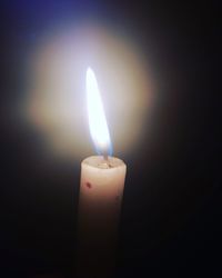 Close-up of illuminated candle against black background