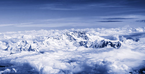 Scenic view of snow mountains against blue sky