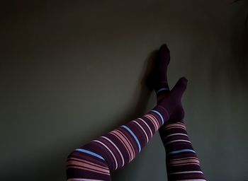 Low section of woman wearing leggings against wall