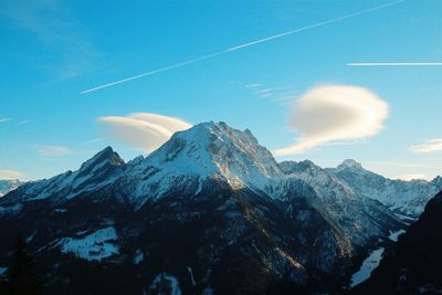 Scenic view of snowcapped mountains against blue sky