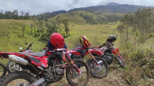 Bicycles parked on field by mountain