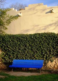 Empty bench on landscape against cloudy sky