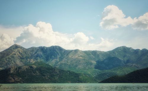 Scenic view of sea and mountains against sky