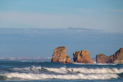 Scenic view of sea and rock formations against sky