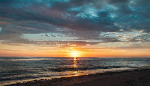 Scenic view of beach against sky during sunset